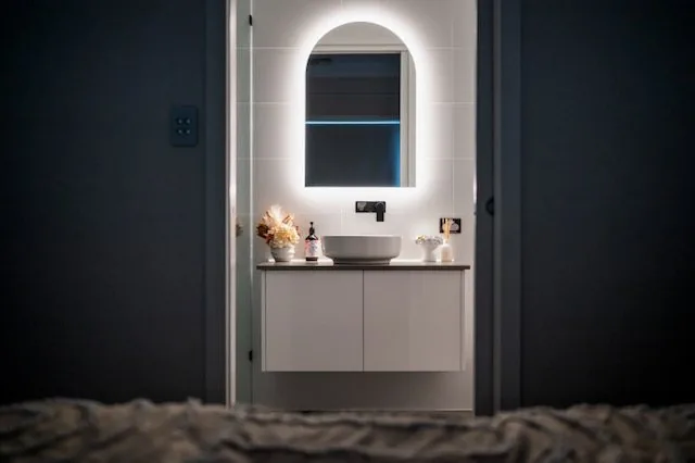 Ensuite seen from the bedroom with lit mirror and floating vanity