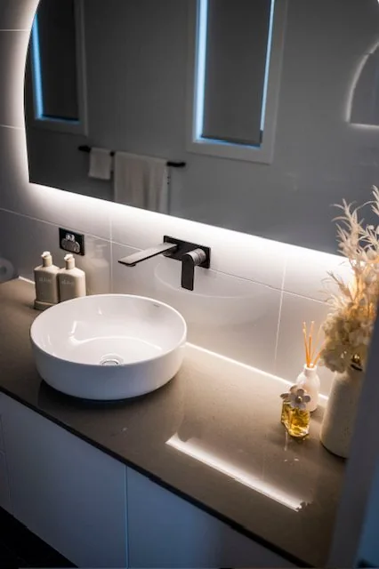 Floating vanity with vessel basin and full height tiling
