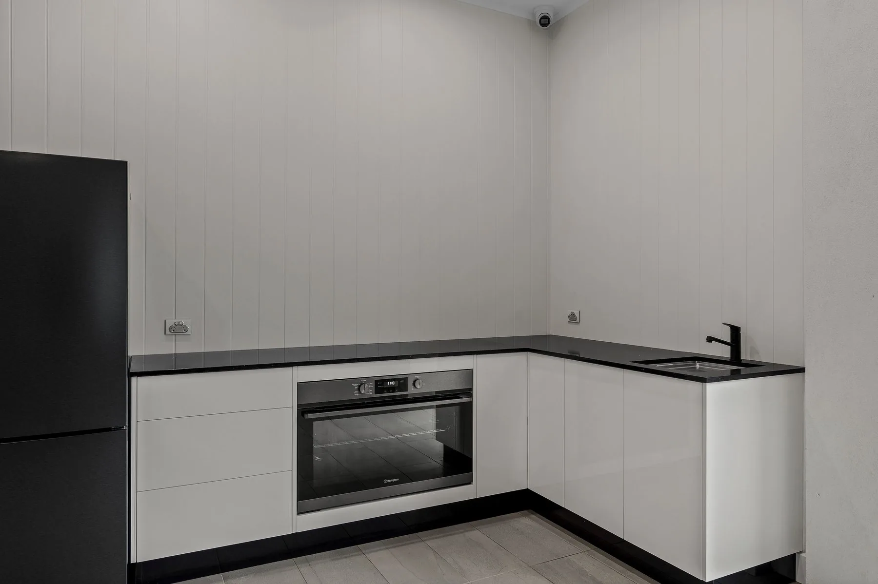 Outdoor kitchen with built in oven, cooktop and full cabinetry run