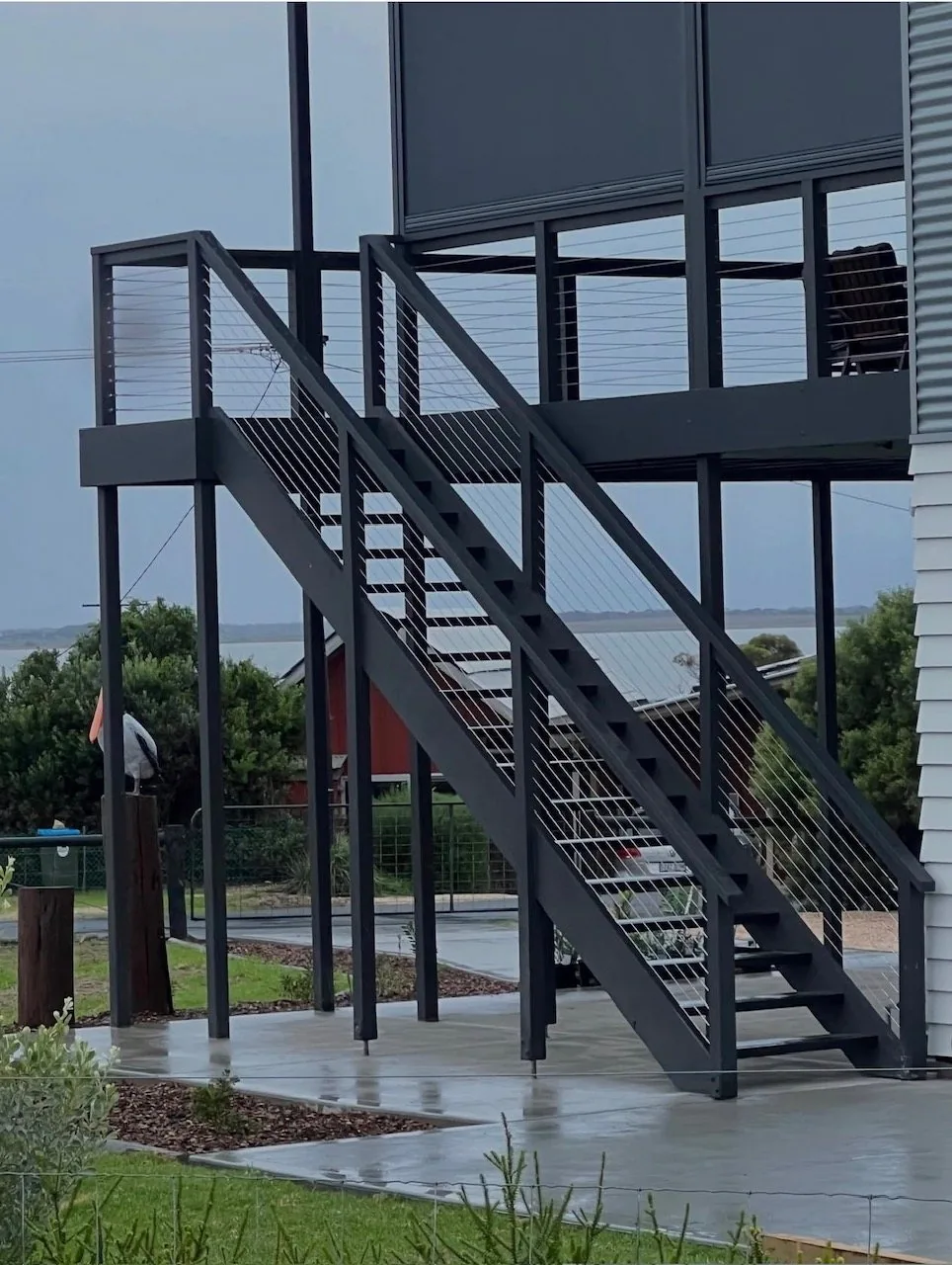 Elevated steel deck and staircase with stainless cable balustrade