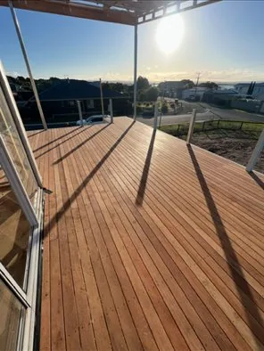 Hardwood deck with glass and cable balustrade photographed at sunset