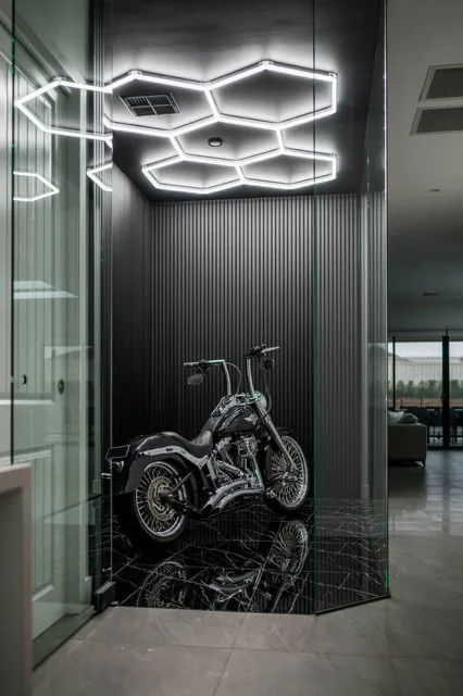 Glass display room with hex lighting and fluted black panelling